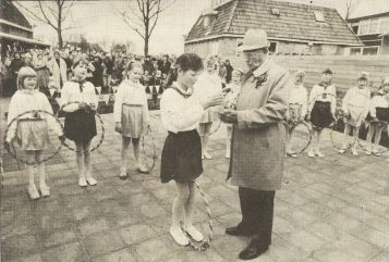 De 84-jarige R. de Jong, oudste nog in leven zijnde oud-leerling van de schooi in Tjerkwerd, ontvangt van één van de leden van een dansgroepje de sleutel van De Regenboog..